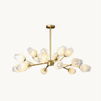 Gold-finished chandelier with frosted faceted glass shades on branching arms, this Clérachic ceiling light shown on a plain cream backdrop.