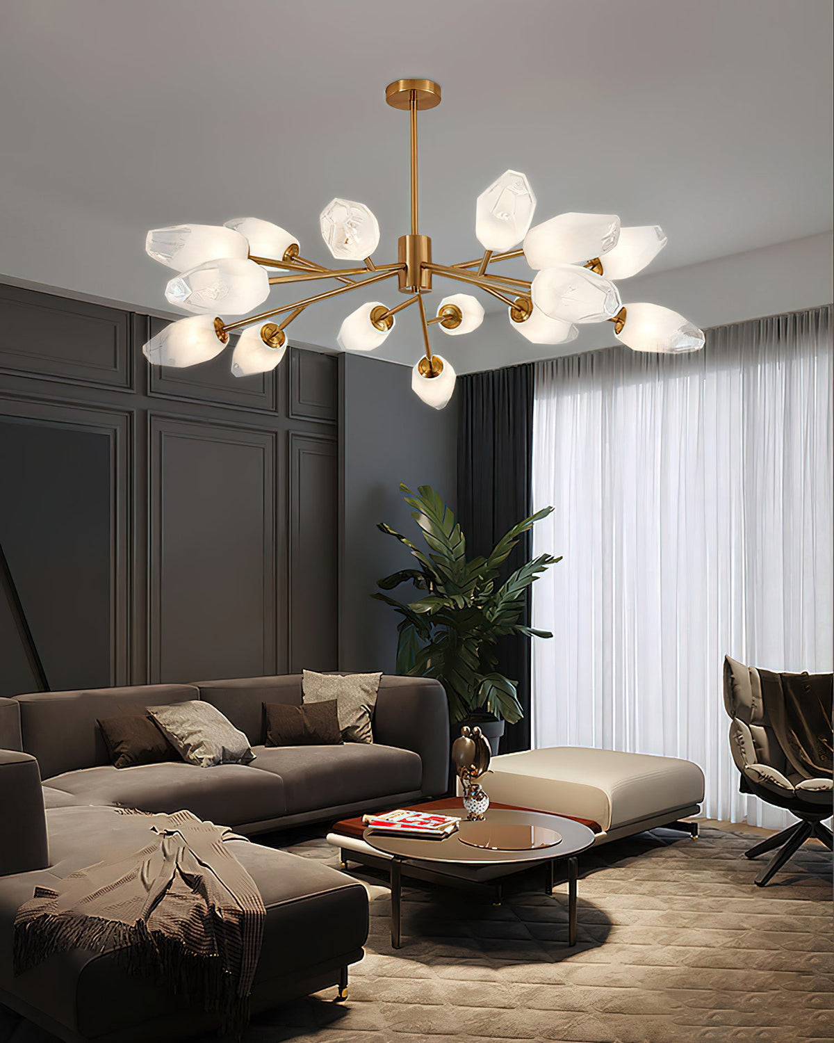 Brass chandelier with frosted glass shades in a living room with taupe sofa and tall sheer curtains, a Clérachic light.