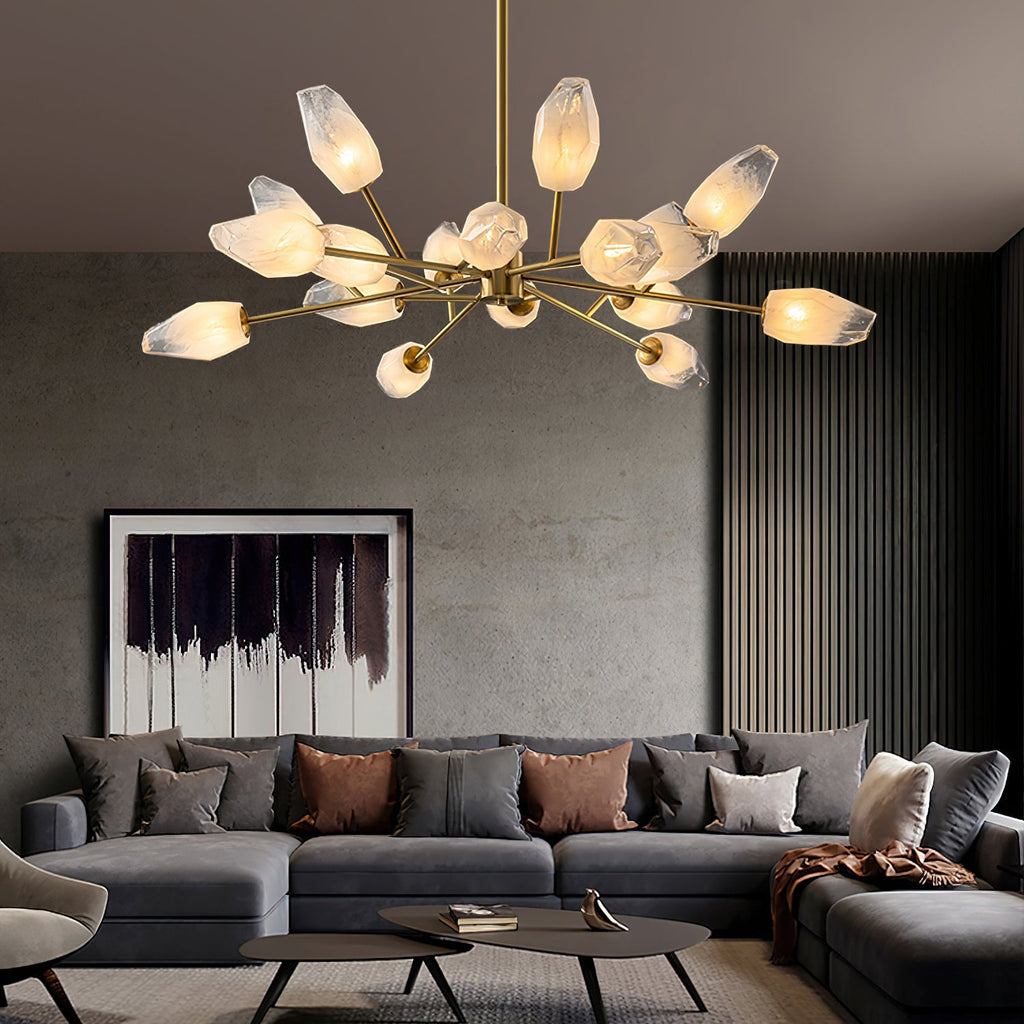 Lit Clérachic chandelier with many frosted shades above a large grey corner sofa in a living room with slatted walls.