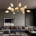Lit Clérachic chandelier with many frosted shades above a large grey corner sofa in a living room with slatted walls.