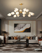 Clérachic chandelier lit in a living room with a coffered ceiling edge, a cream sofa and a framed abstract artwork.