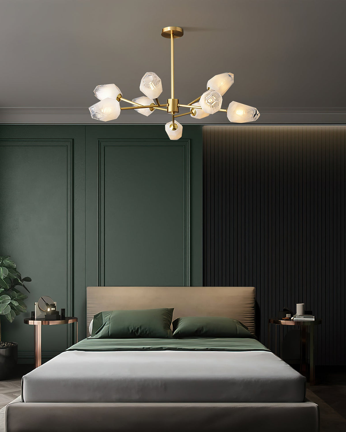 Brass chandelier with a handful of frosted shades above a low grey bed in a room with olive-green panelled walls, a Clérachic light.