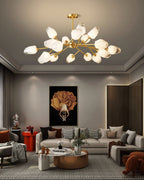 Clérachic chandelier lit in a grey living room with a coffered ceiling and a bold orange framed picture on the wall.