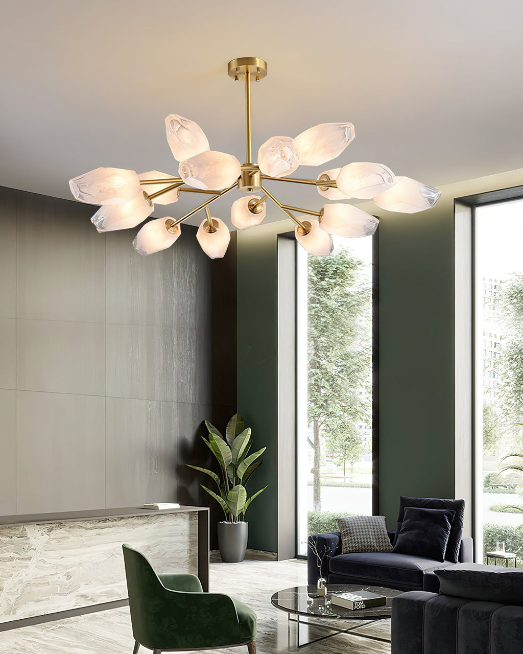 Clérachic chandelier with many frosted shades in a tall lobby-style room with a marble desk and a green armchair.