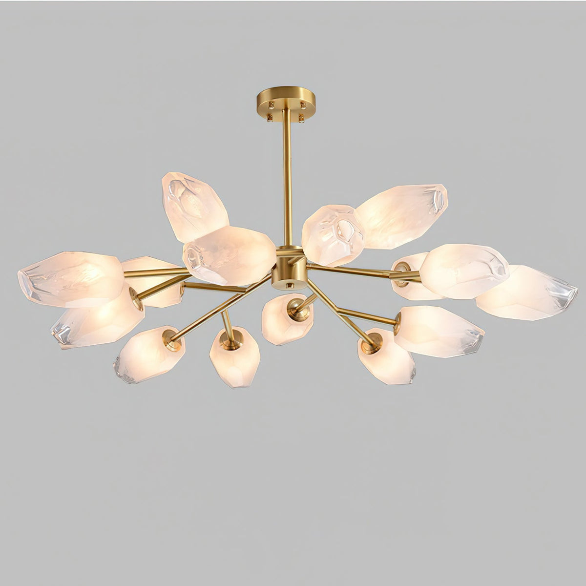 Gold chandelier with frosted glass shades in a soft glow, this Clérachic ceiling light on a plain light grey backdrop.