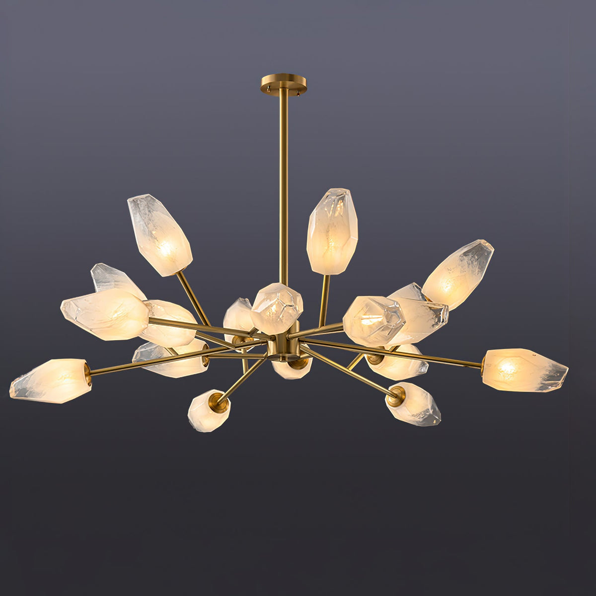 A Clérachic chandelier with many warmly lit frosted shades spread wide on a dark grey-blue studio backdrop.