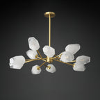 Unlit Clérachic chandelier showing its white faceted glass shades and brass arms against a black backdrop.
