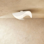 A curved, sail-shaped Clérachic ceiling light in matte white mounts flush against a plastered ceiling.