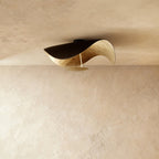 Seen at an angle, this Clérachic ceiling fixture pairs a black outer shell with a gilded gold-leaf interior.