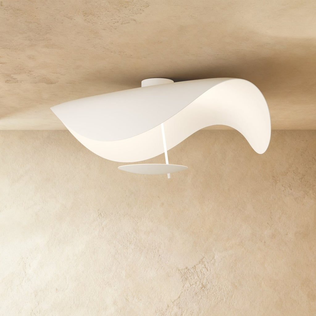 From another angle, the matte white sail form of this Clérachic ceiling light reveals its slim brass rod and disc diffuser.