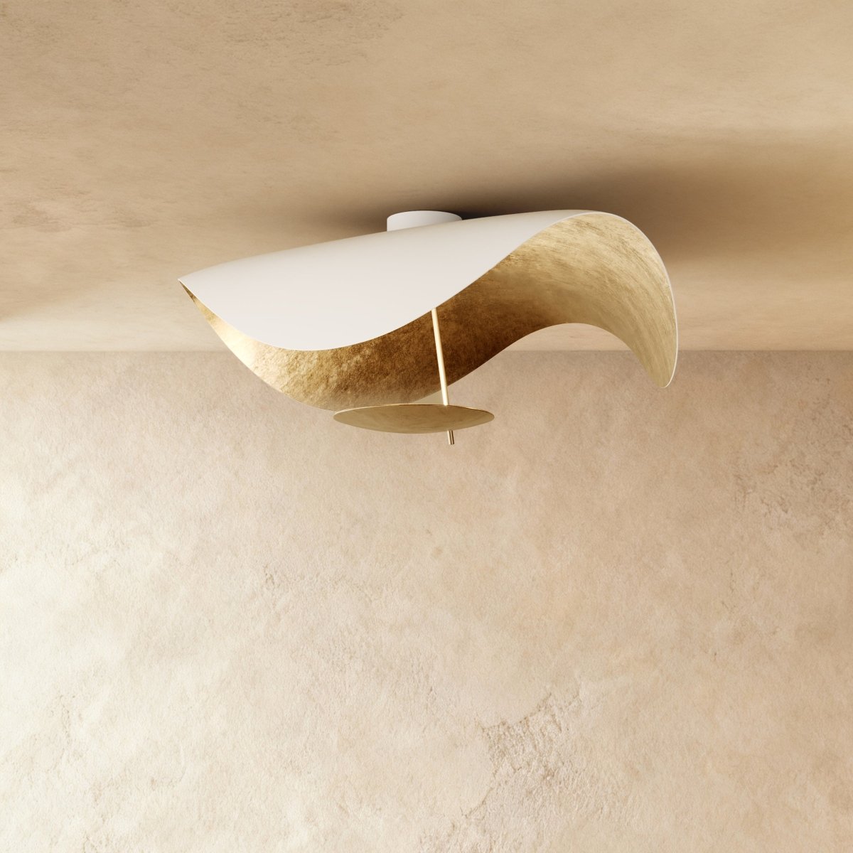 A near view of the white-and-gold Clérachic ceiling light, its curved shade cradling a slim brass stem and disc.