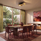 Over a wooden dining table, the black-and-gold Clérachic ceiling light adds a sculptural focal point to the room.