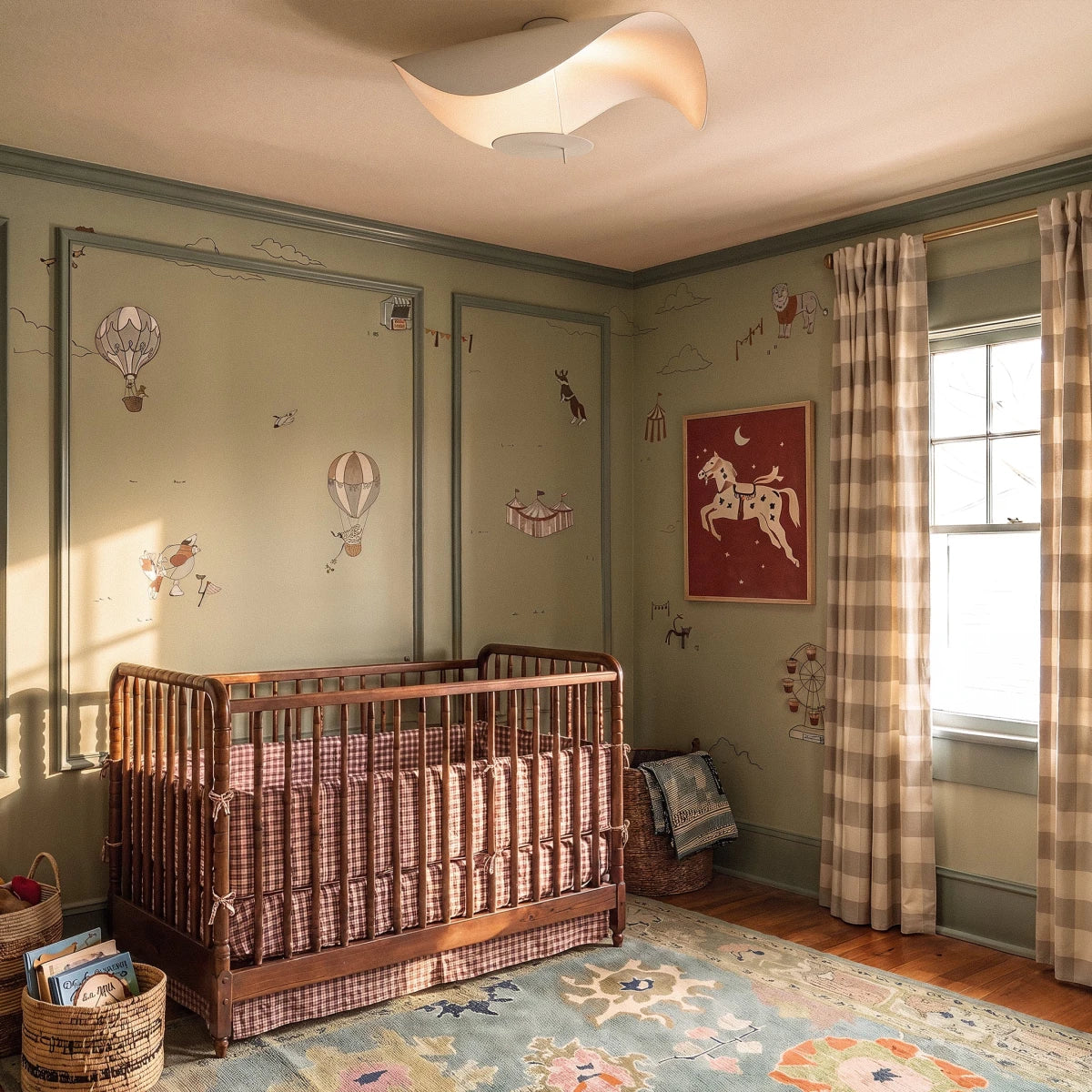 Switched on above a wooden crib, the matte white Clérachic ceiling light casts a soft glow across a patterned nursery.