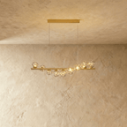 Clérachic gold linear chandelier with nine smoke-tinted glass globes glittering with small lights along a slim brass bar.