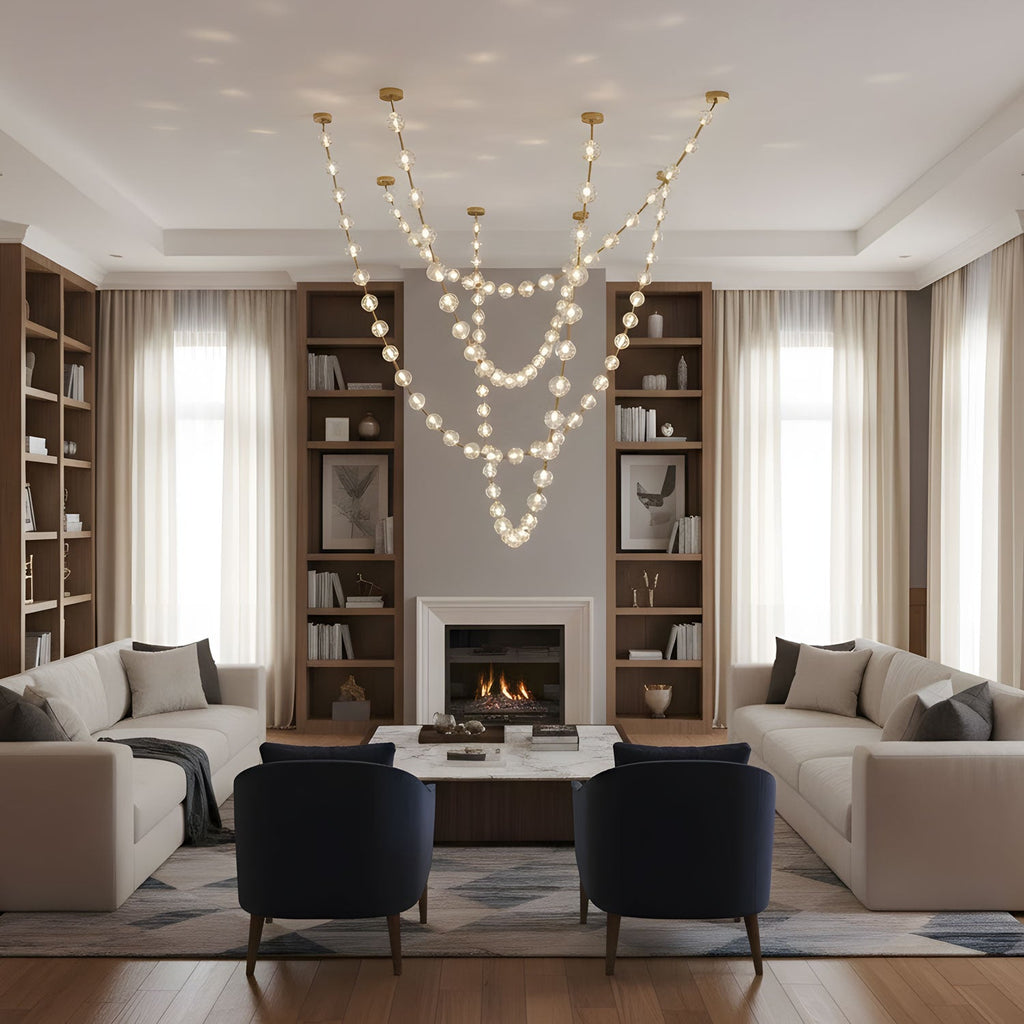 Several lit strands fall from a high ceiling in a double-height living room with bookshelves, a fireplace and cream sofas, lit by this Clérachic pendant.