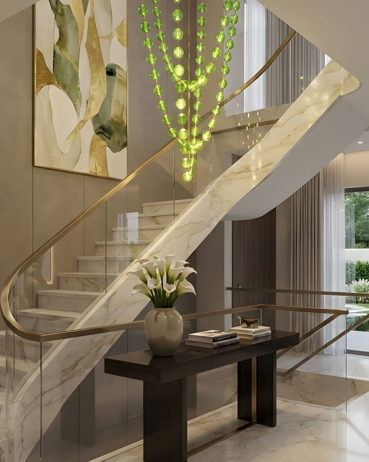 Green sphere strands in the Gold & Green finish fall beside a curving marble staircase with a glass balustrade, part of this Clérachic pendant.