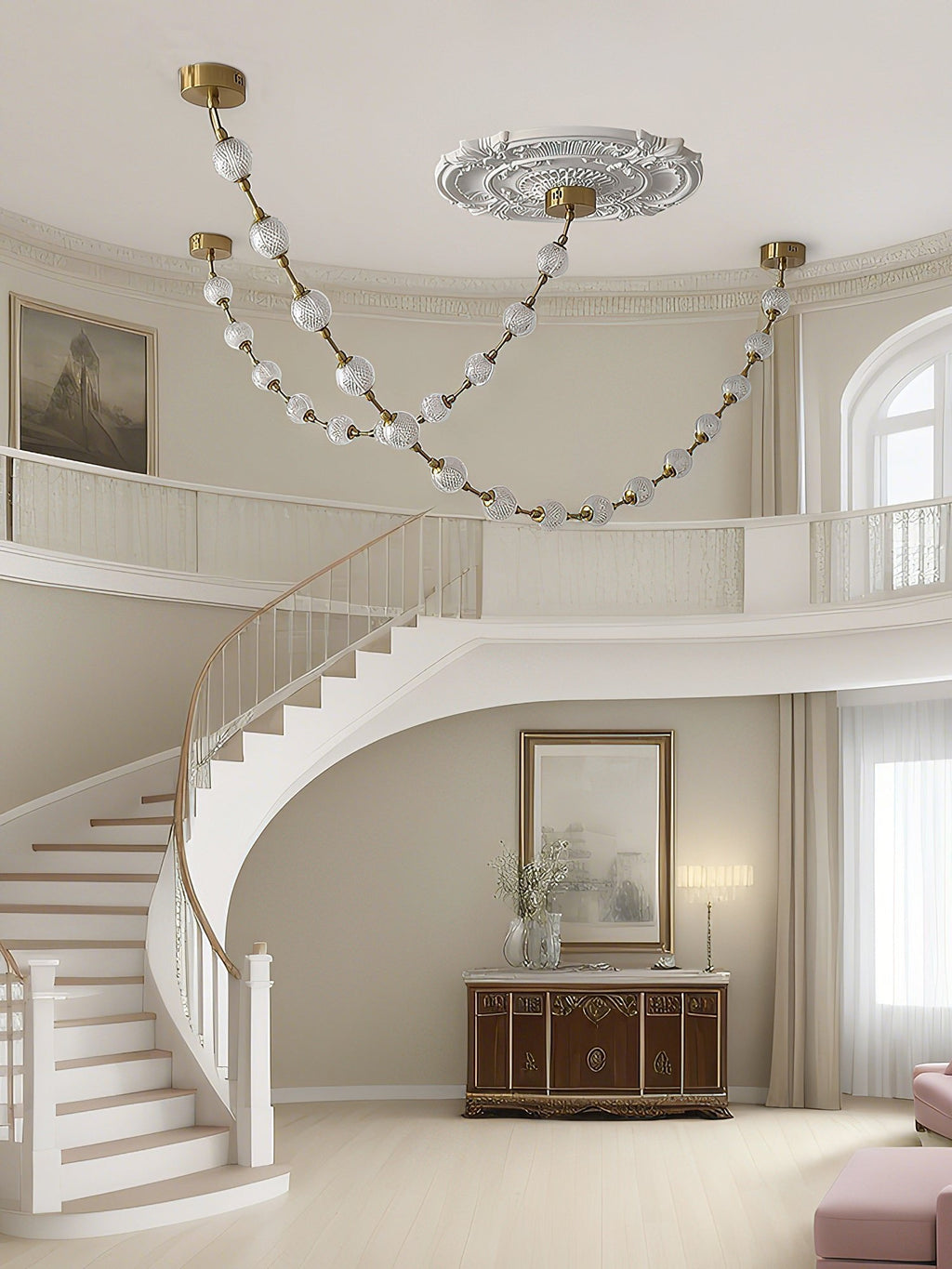 Beaded strands in frosted glass loop across a ceiling beside a curved white staircase and landing, a Clérachic pendant above a carved wooden sideboard.
