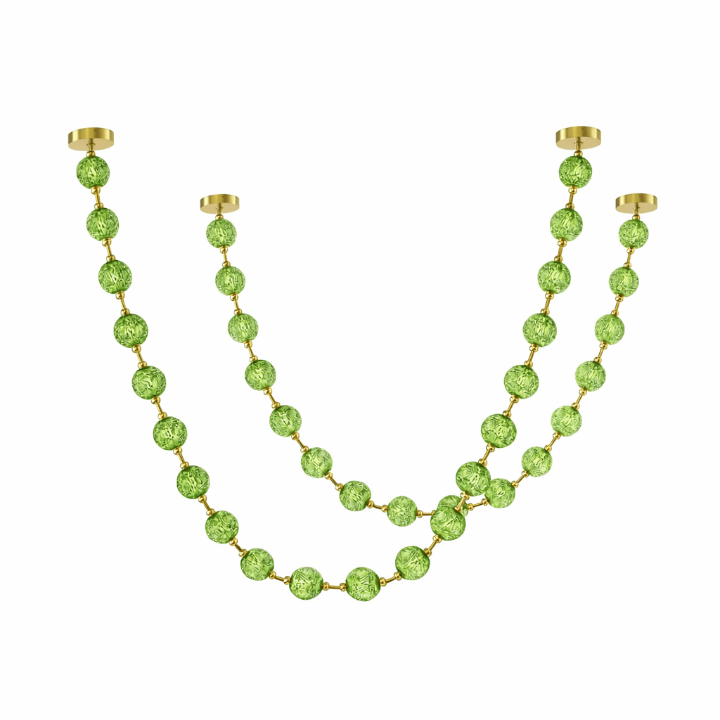 Two green strands of this Clérachic pendant hang from four brass plates, the longer strand using larger spheres, on white.