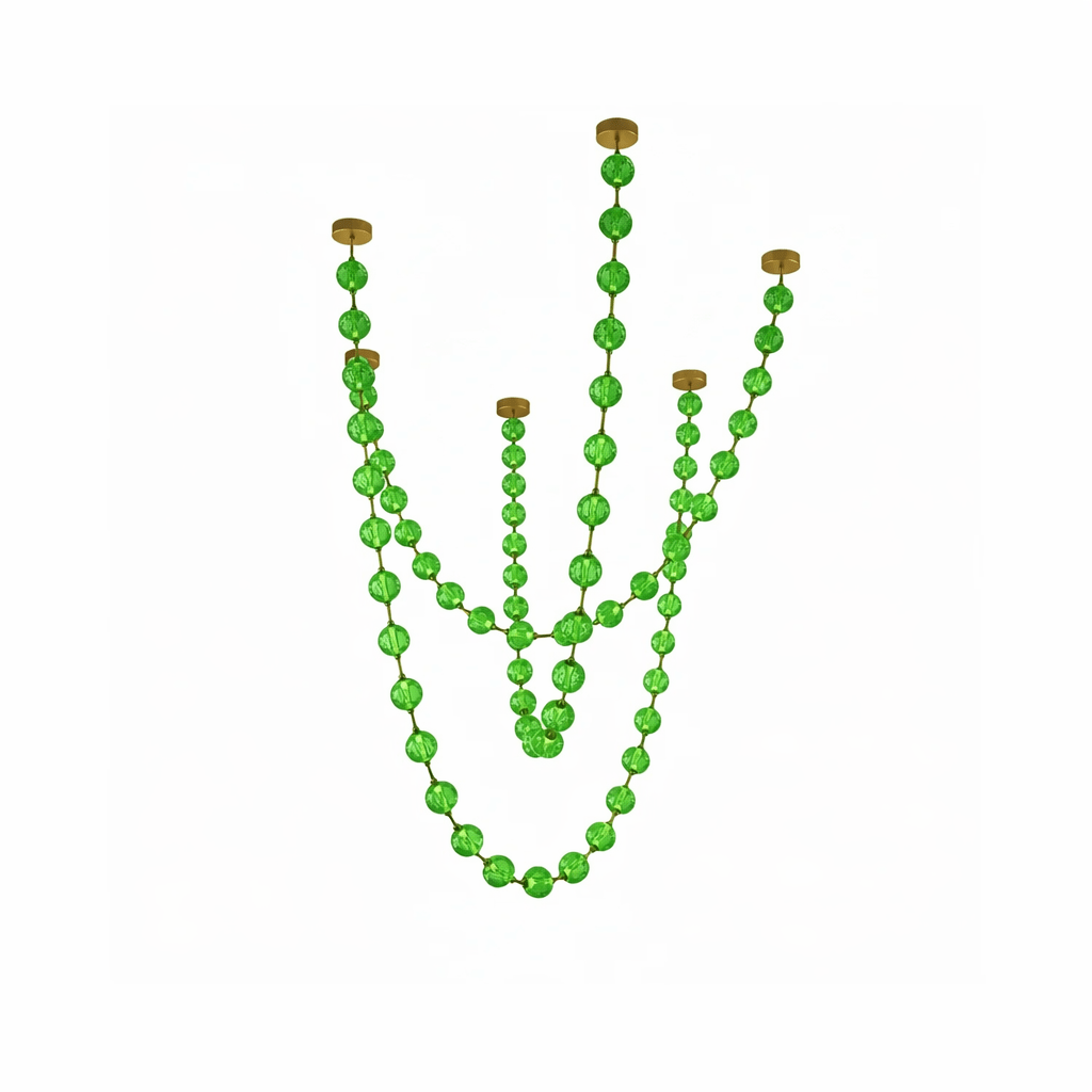 Green spheres on gold links hang in five uneven strands, from this Clérachic pendant, on a pale background.