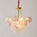 Clérachic pendant with a gold canopy and looped pearls, its tiered pink and white glass discs glowing on a grey backdrop.
