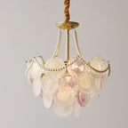 Clérachic glass-disc pendant on a grey backdrop, with a narrower tier of pink and white discs and long pearl strands.