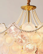 Close view of the ridged glass discs, in pink and clear frosted tones, and the pearl swag on this Clérachic pendant.