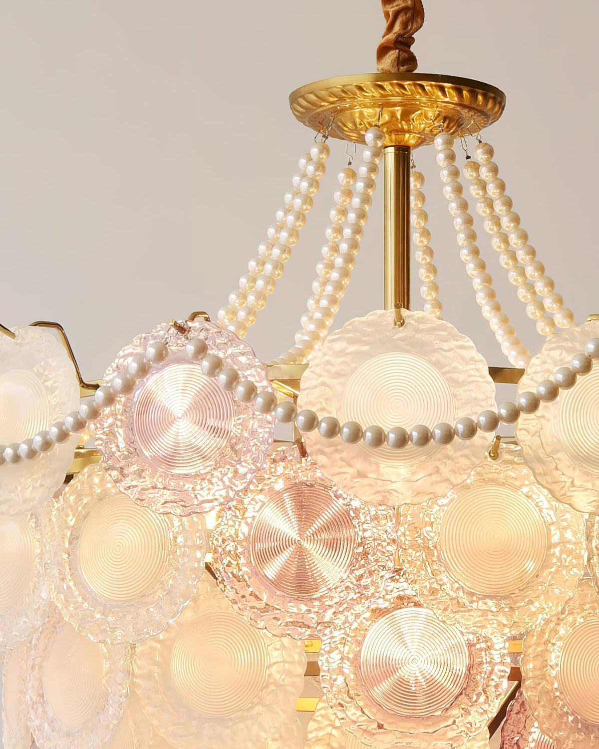 Close view of the ridged glass discs, in pink and clear frosted tones, and the pearl swag on this Clérachic pendant.