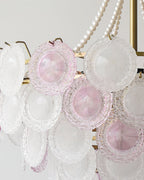 Close view of the concentric ridges on the pink and frosted glass discs of this Clérachic pendant, with pearls beside them.