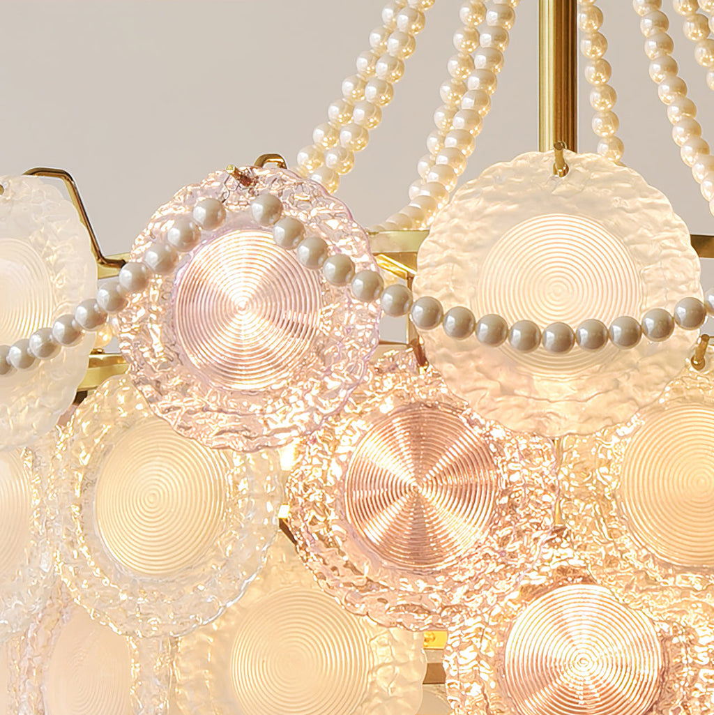 Close view of the textured glass discs of this lit Clérachic pendant, in rose and warm white, with ridges around each disc.