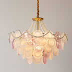 This Clérachic pendant lit on a plain grey backdrop, with a pearl swag across the front and layered pink and frosted discs below.