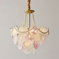 A lit Clérachic pendant shown with tall pearl strands and pale glass discs in soft pink and white, on a grey backdrop.