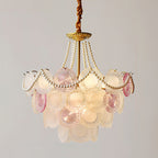 Clérachic glass-disc pendant, lit, with a gold canopy at the top and a mix of rose and frosted discs in three tiers.