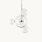 Clérachic glass sphere pendant with a large clear globe and three smaller spheres around a gold central disc, on a plain white backdrop.