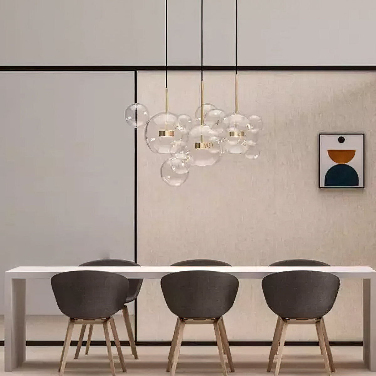 A group of Clérachic glass sphere pendants above a pale dining table with dark chairs and a framed print on the wall.