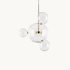 Clérachic glass sphere pendant with a large globe and three small spheres on a gold stem, on a cream backdrop.