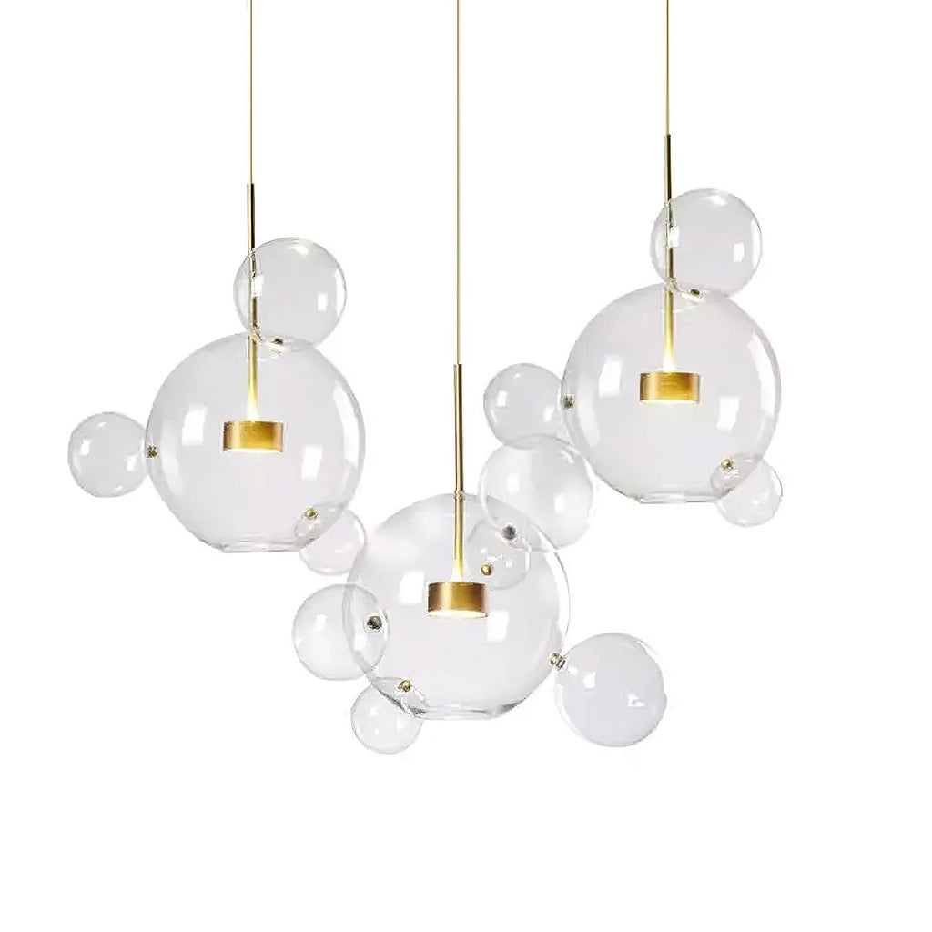 Three Clérachic glass sphere pendants with gold stems and mixed clear spheres, shown together on a white backdrop.