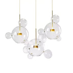 Three Clérachic glass sphere pendants with gold stems and mixed clear spheres, shown together on a white backdrop.