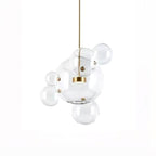 Clérachic glass sphere pendant with a large globe, a gold disc and four smaller spheres attached, on a white backdrop.