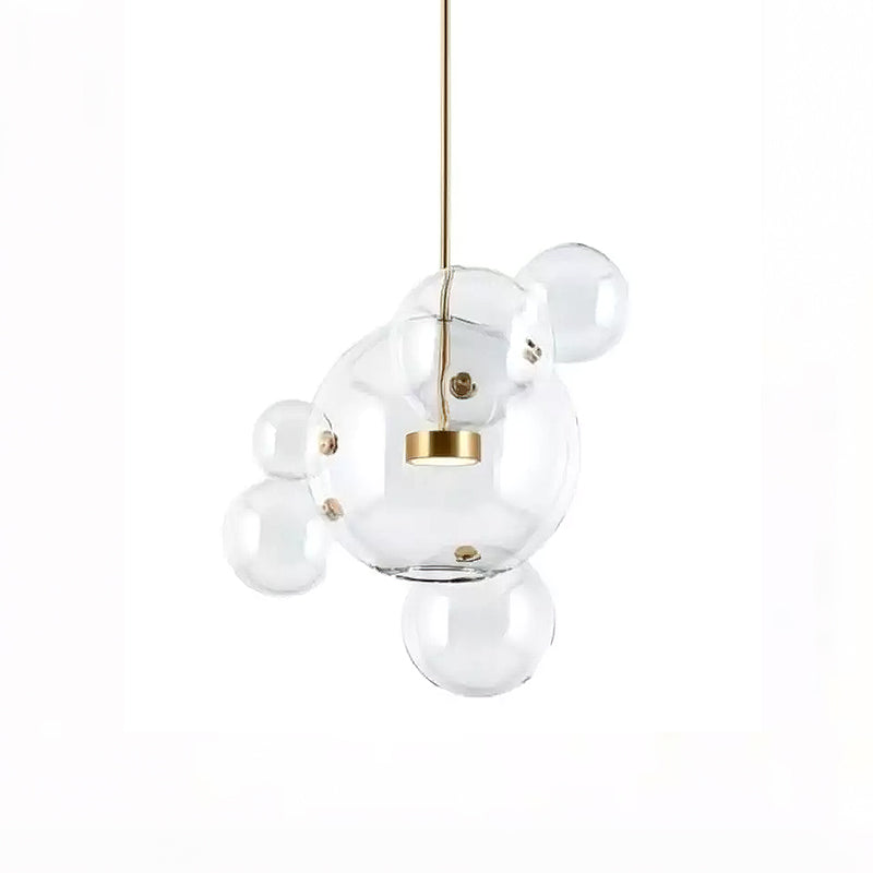 Clérachic glass sphere pendant with a large globe, a gold disc and four smaller spheres attached, on a white backdrop.