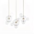 Three Clérachic glass sphere pendants hung at different heights, with small clear spheres between them, on a white backdrop.