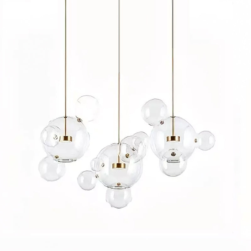 Three Clérachic glass sphere pendants hung at different heights, with small clear spheres between them, on a white backdrop.