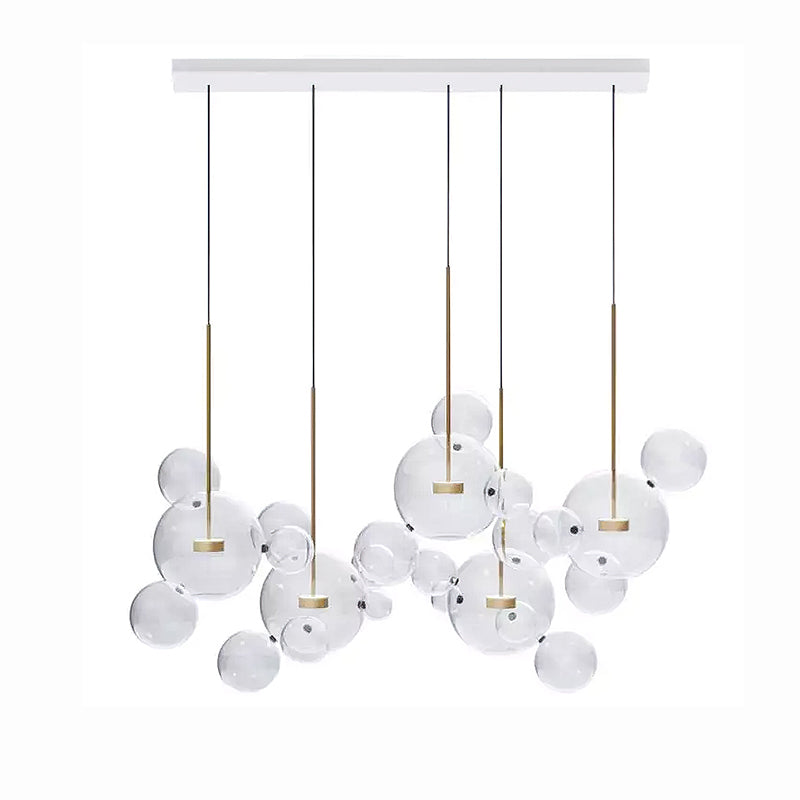 Five Clérachic glass sphere pendants on a white rectangular ceiling plate, with clear spheres between the stems.