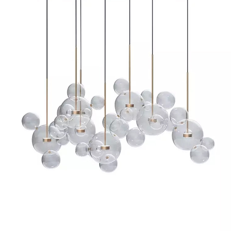 Wide Clérachic glass sphere installation with many pendants hung at different heights, on a white backdrop.