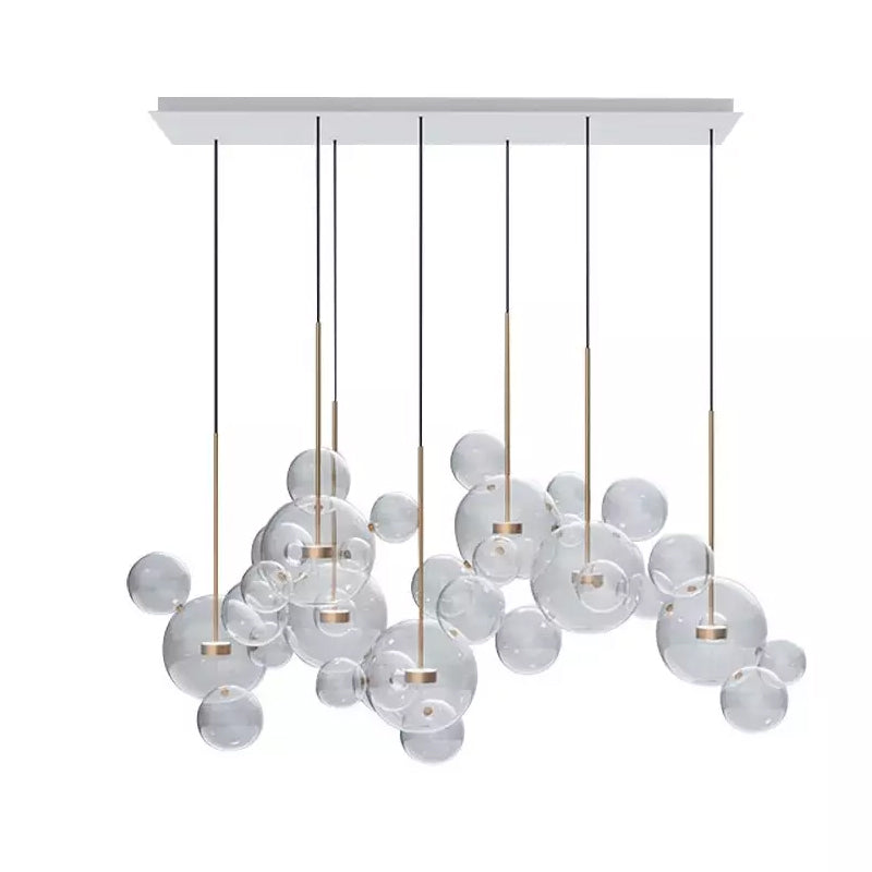 Wide Clérachic glass sphere installation seen from the front, with dark cables and clear spheres, on a white backdrop.