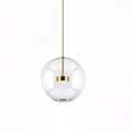 Clérachic clear glass globe pendant with a gold disc at its centre, on a white backdrop.