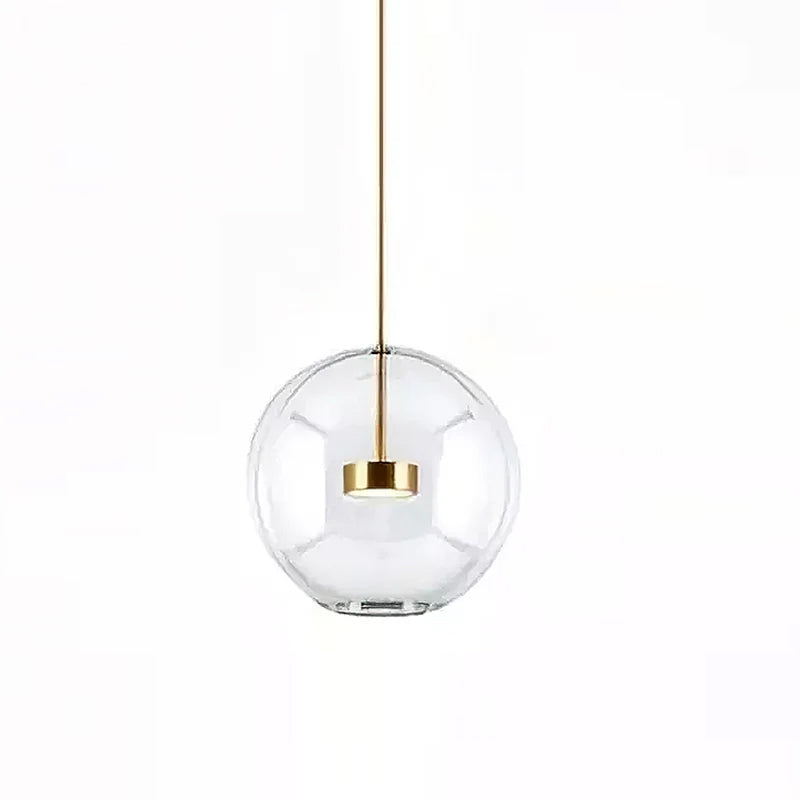 Clérachic clear glass globe pendant with a gold disc at its centre, on a white backdrop.