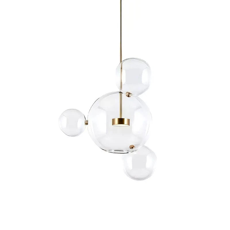 Clérachic glass sphere pendant with a large globe and three small spheres on a gold stem, on a white backdrop.
