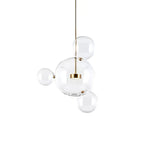 Clérachic glass sphere pendant with a large globe and three small spheres on a gold stem, on a white backdrop.