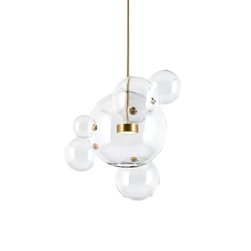 Clérachic glass sphere pendant with one large globe and several small spheres, on a gold stem against a white backdrop.