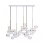 Five Clérachic glass sphere pendants hung from a white rectangular ceiling plate, with clear spheres between them.